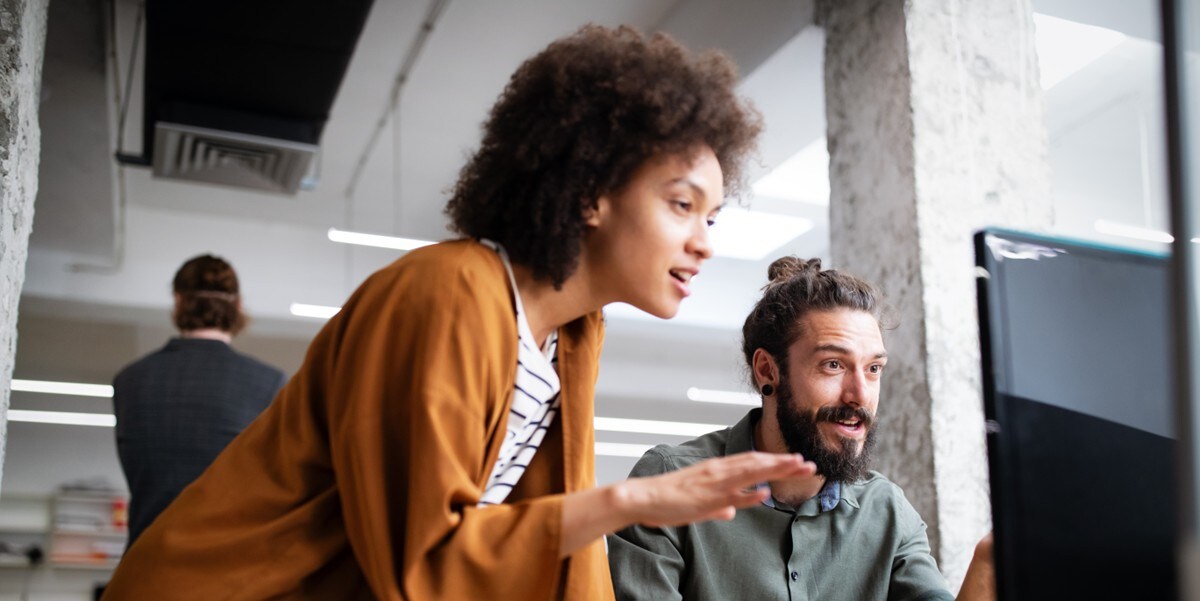two professionals in the office looking at computer