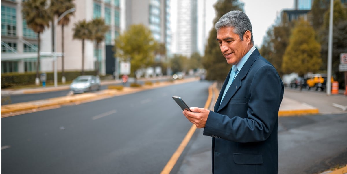 hombre parado afuera con celular, ciudad