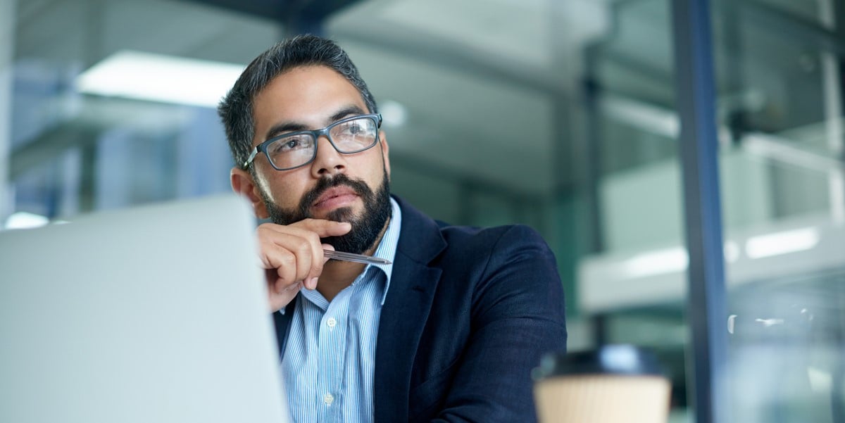 professional in office, working at desk with laptop